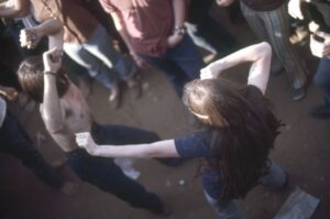 Overhead view of two people dancing in the crowded audience during the Sound Storm music festival. One of them is shirtless and the other wears a dark blue t-shirt with a headband in his or her hair. (Courtesy of Wisconsin Historical Society)