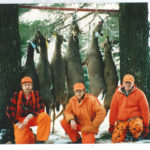 Brothers Jim, Gary, and Ron Weber: hunting partners among the trees with their deer.