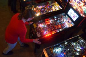 Hilton Jones, co-founder of Madison Pinball, plays the Deadpool pinball machine at I/O Arcade Bar in Madison, Wis. (Jenny Peek/WPR)