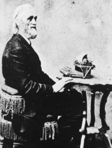 Portrait of Christopher Latham Sholes posing at a typewriter. (Courtesy of Wisconsin Historical Society)