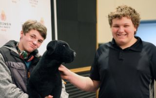 MG21 students Ashton Botts, left, and Preston Ivey with the WPR stuffed dog on a field trip to the station. (Jenny Peek/WPR)