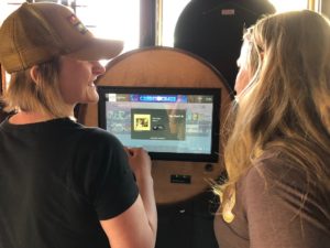 Briana Rupel and Rachel Luehring pick a Tom Petty song on the jukebox at Del's. (Maureen McCollum/WPR)