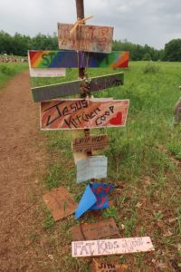 Signs designate different kitchens or camps that people can go to at the Rainbow Family gathering on July 4, 2019. (Danielle Kaeding/WPR)