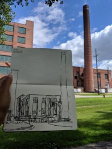 Nishant Jain holds his sketchbook to show his interpretation of a factory near downtown Eau Claire. He recently taught a class on urban sketching in Chicago and visited a local high school to talk about his work in June. (Courtesy of Nishant Jain)