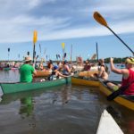 Paddles up and cheers go out as the 2019 PaddleQuest sets off. (Rob Mentzer/WPR)