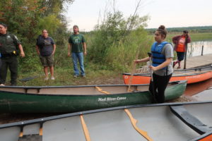 Tribal members and 17 year-old Kreighton Wolf are getting ready for kids to go out and harvest wild rice on Pacwawong Lake. (Danielle Kaeding/WPR)