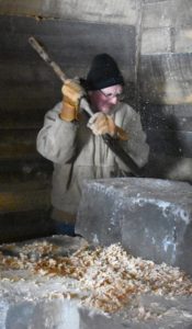 Frost flies as Don Matthews, president of Historic Point Basse, chips at the ice blocks to ensure that they stack straight at the historic icehouse in Wood County, January 26, 2020. (Rob Mentzer/WPR)