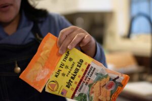 A hand holds a package of Vietnamese pancake flour.