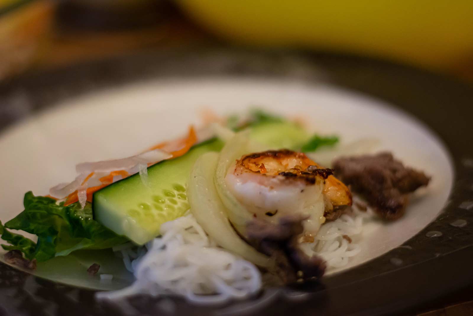 Cucumber, shrimp, carrots, lean beef, sprouts, lettuce and daikon sit on a plate.