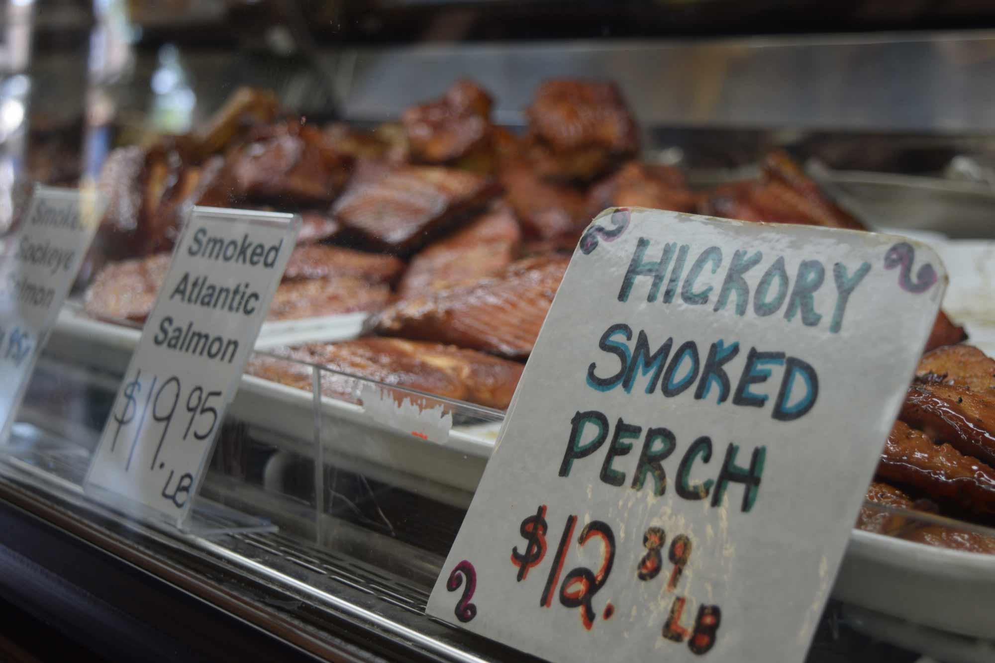 Handwritten sign in display case. Hickory smoked perch $12.89 per pound.