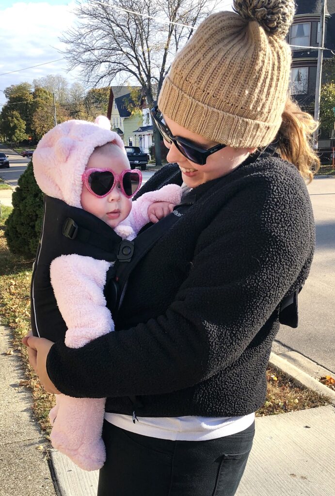 Andrea Anderson, right, holds her daughter Magnolia Grube, left, before heading on a family walk in Janesville, Wis. in Oct. 2020. (Andrea Anderson/WPR)