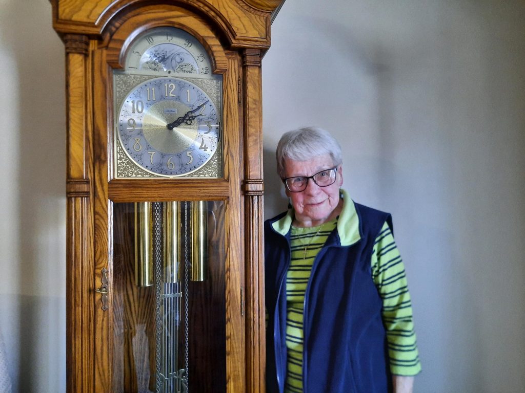 Leona Schumacher with her grandfather clock. (Photo by Ben Meyer/WXPR)
