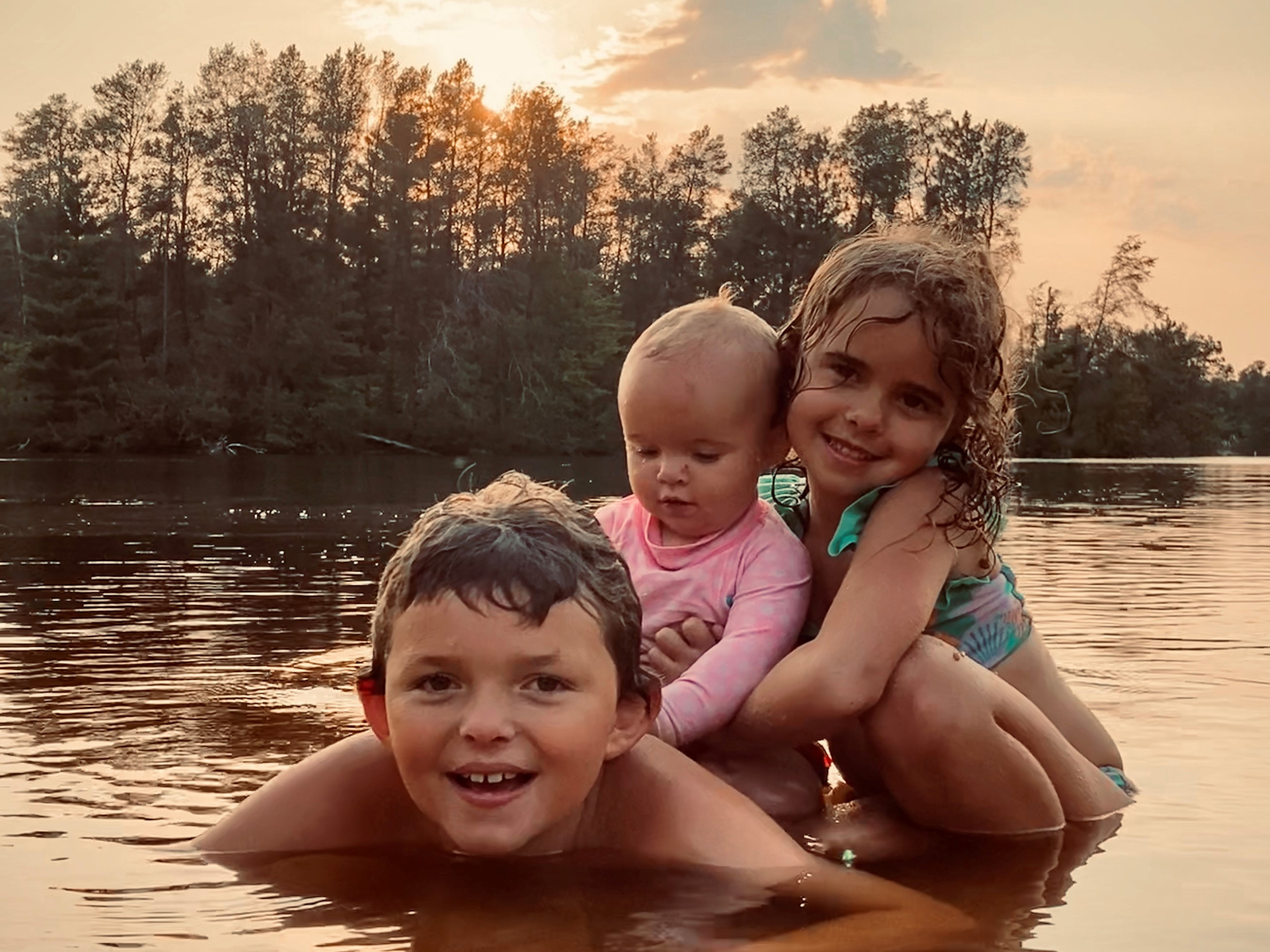 The Hollars children play in Coon Fork Lake in Augusta, Wisconsin. (Photo by BJ Hollars)