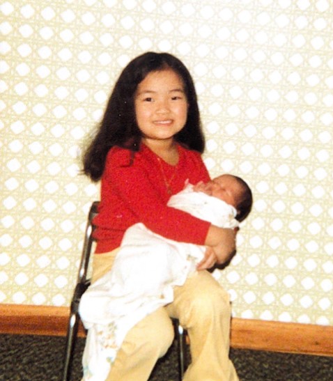 Five year-old Mixee Vang holds her sister, Thiney Vang. (Courtesy of Mixee Vang)