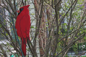 A wooden cardinal perched in a tree.