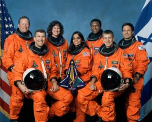 The seven STS-107 crew members take a break from their training regimen to pose for the traditional crew portrait. Seated in front are astronauts Rick D. Husband (left), mission commander, and William C. McCool, pilot. Standing are (from left) astronauts David M. Brown, Laurel B. Clark, Kalpana Chawla and Michael P. Anderson, all mission specialists; and Ilan Ramon, payload specialist representing the Israeli Space Agency. (Photo courtesy of NASA)
