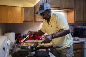 Osvaldo Durruthy makes food in his home in Madison, Wisconsin, on April 19, 2021. (Angela Major/WPR)