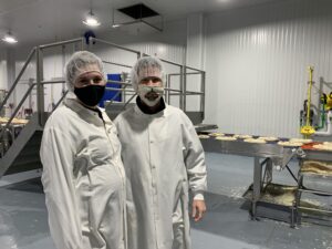 Bernatello’s marketing team Adrianna Frelich and Matt Selvig inside the Kaukauna frozen pizza manufacturing plant. Now Marketing Manager, Frelich began her career at Bernatello’s working on the production line as a summer job. (Photo by Jana Rose Schleis)