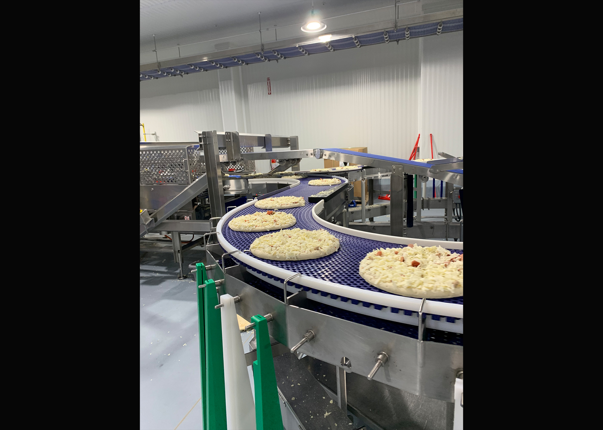 Frozen pizzas made in Wisconsin are on their way to being wrapped, packaged and then shipped to groceries stores across the Midwest. (Photos by Jana Rose Schleis)