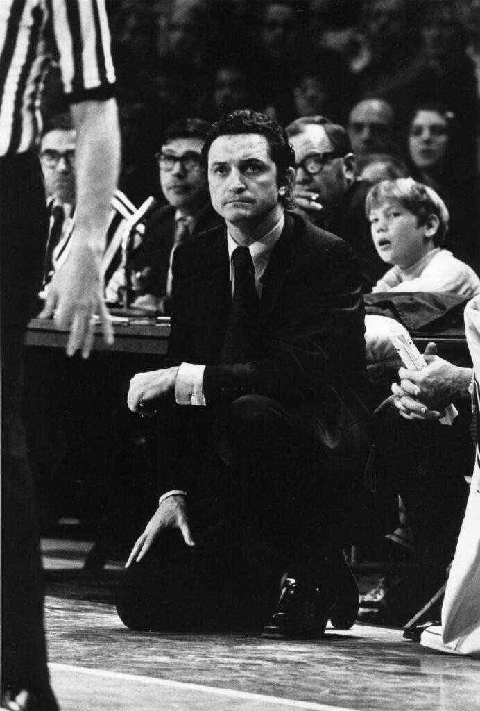 Marquette basketball coach Al McGuire kneels down during a game, 1974-1977. (Courtesy of the Department of Special Collections and University Archives, Raynor Memorial Libraries, Marquette University)