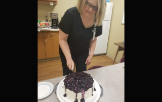 Kathy Gregersen, who works with Dr. Arif Ahmad, cuts a cake to mark the end of Ramadan. (Courtesy of Arif Ahmad)
