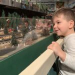 A young boy smiles as he watches model trains at the Lionel Railroad Club's open house. (Photo by Jane Hampden)
