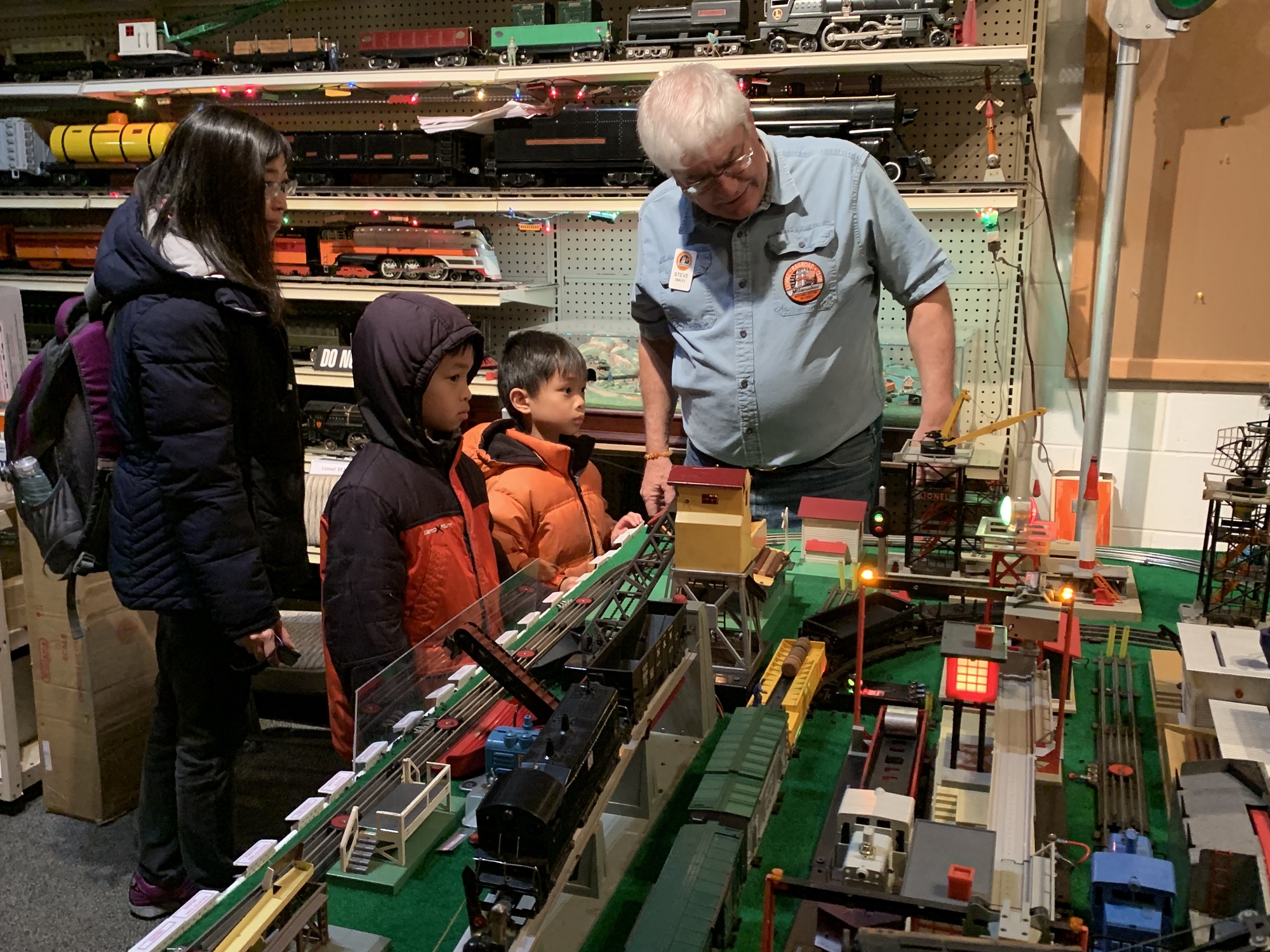 Lionel Railroad Club president Steve Smiley demonstrates the train setup for a family from New Berlin. (Photo by Jane Hampden)