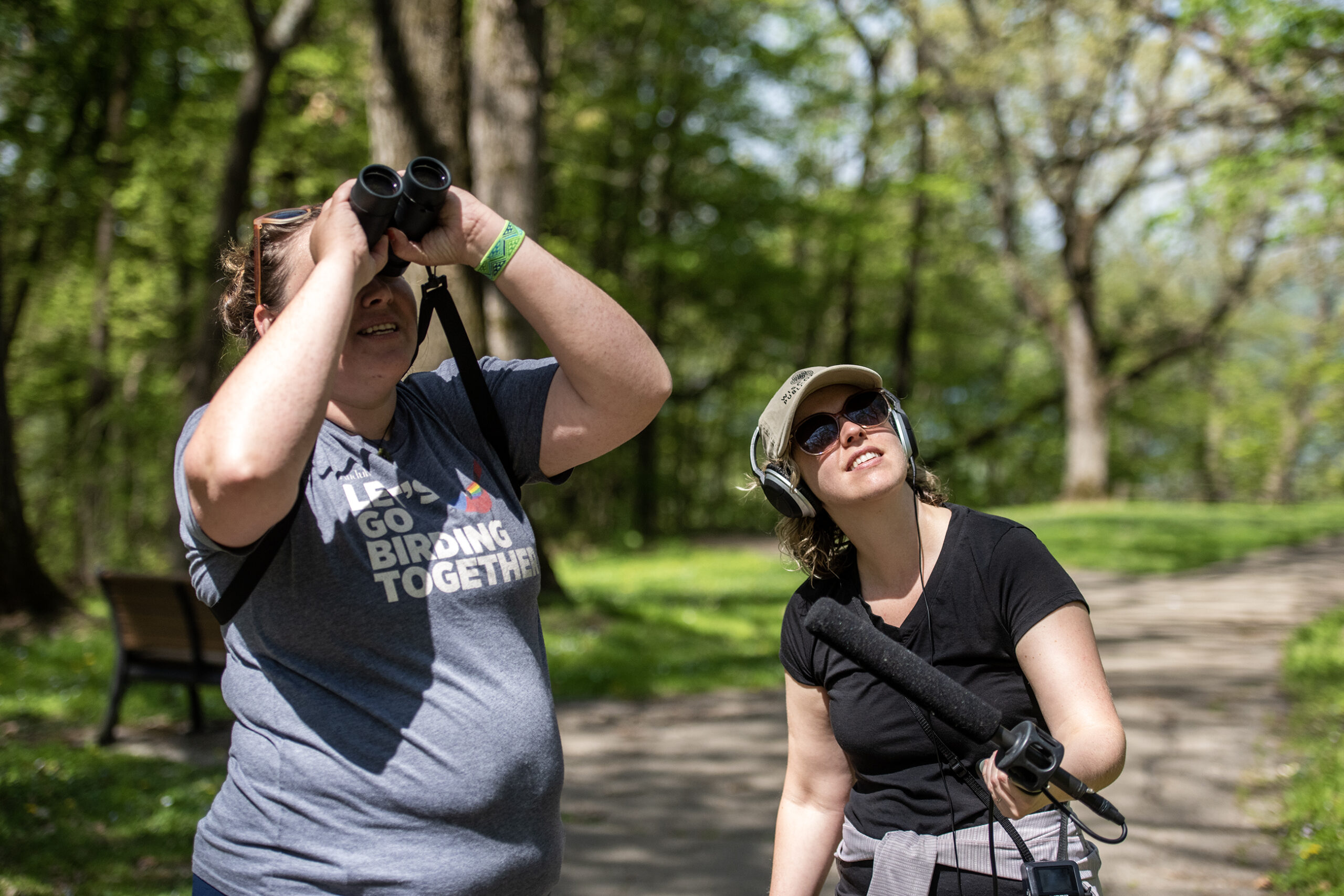 Kari Hagenow, left, a land steward and conservation project manager at The Nature Conservancy in Wisconsin, explains the birds she sees as Wisconsin Public Radio reporter Bridgit Bowden, right, records audio Wednesday, May 10, 2023, at Wyalusing State Park in Bagley, Wis. (Angela Major/WPR)