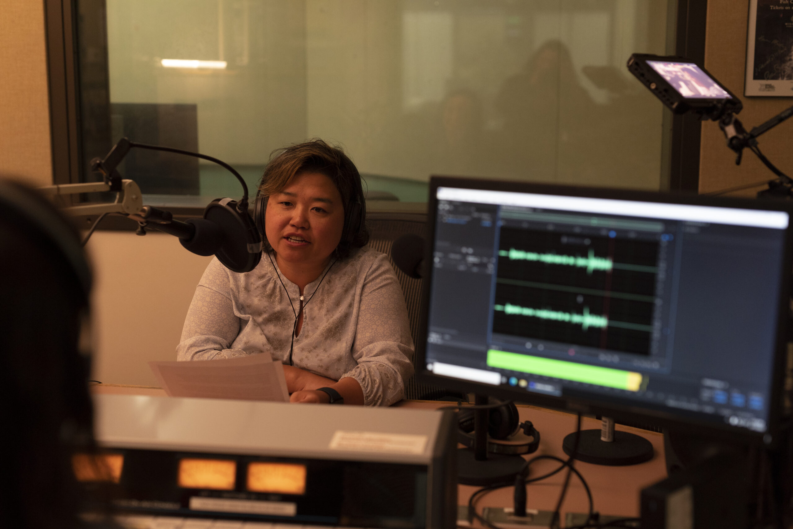 Mai Lo Lee records her story for the "Home Is Here" project in Wisconsin Public Radio's Green Bay studios on May 17, 2023. (Photo by Laura Henderson) 