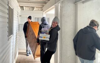 Felicia Diny, founder of the nonprofit Felicia's Donation Closet, and volunteers move a dresser and other items to furnish an apartment. (Gaby Vinick/WPR)