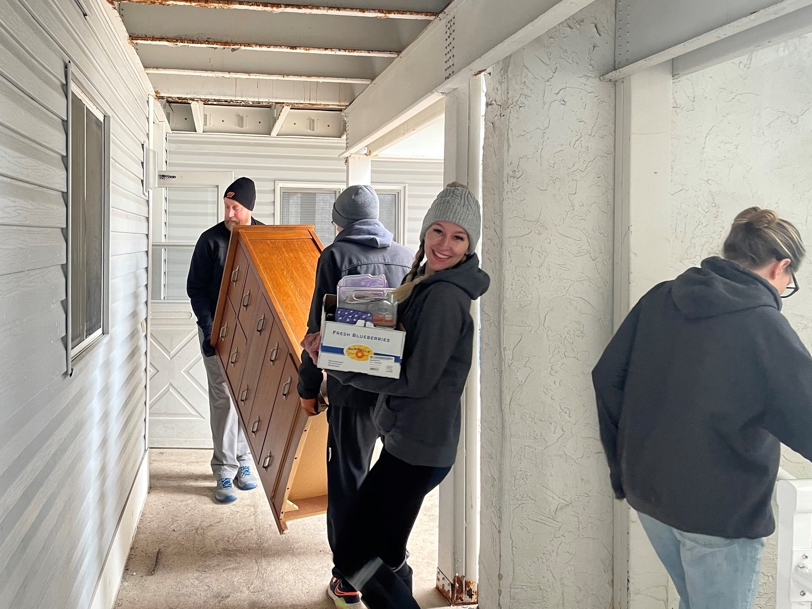 Felicia Diny, founder of the nonprofit Felicia's Donation Closet, and volunteers move a dresser and other items to furnish an apartment. (Gaby Vinick/WPR)