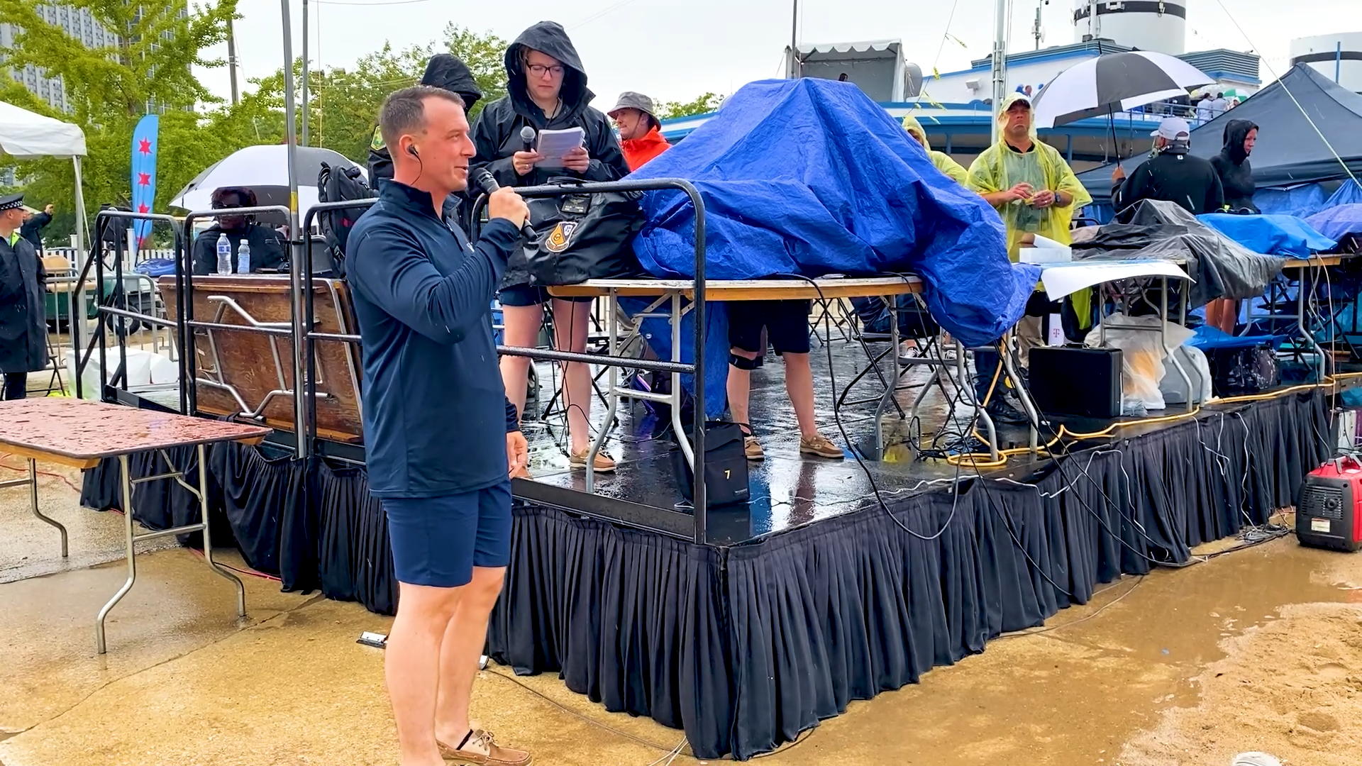 For a year before he joined the six-plane demonstration squadron as Blue Angel #6, LCDR Griffin Stangel served as the air show narrator for the unit, and flew the two-seat #7 plane for media ride alongs. He's seen here narrating in the rain at the 2022 Chicago Air and Water Show. (Photo by Dusty Weis) 