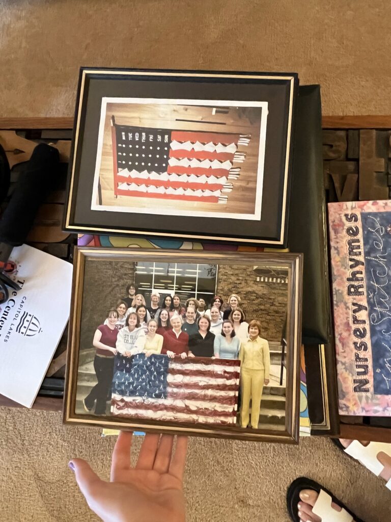 Photos of "The Land of the Freed-up Woman" and a photo of the flag's recreation created by Madison Memorial Hiigh School students in 2002 are framed in Marge Engelman's Madison apartment. (Molly Hunken/WPR)