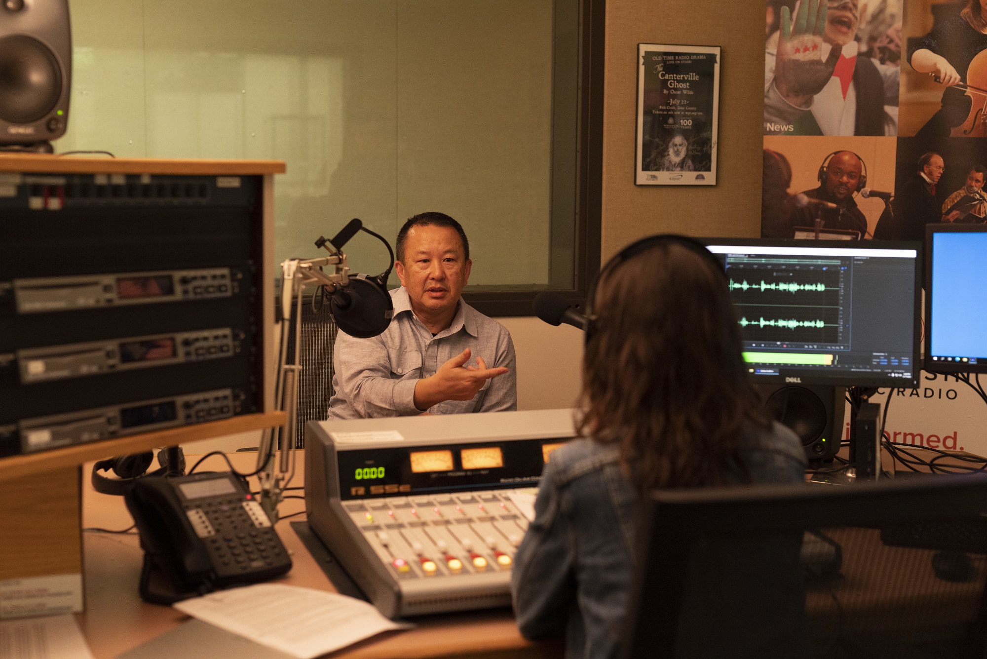 Pao Lor records his story for the “Home Is Here” project in Wisconsin Public Radio’s Green Bay studios on May 17, 2023. (Photo by Laura Henderson)
