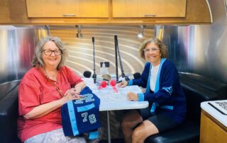 Barb Baryenbruch Luhring (l) and Sue Tringali Johnson reflect on becoming Wisconsin's first high school girls basketball champions. They recorded their conversation in the StoryCorps mobile tour booth on August 16, 2023. (Ellen Clark/WPR)