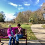 Chris Thomas and Alexandra Salmon sit on a bench in Madison, Wisconsin. Chris would like to establish a similar one in a park as her memorial bench. (Photo by Alexandra Salmon)