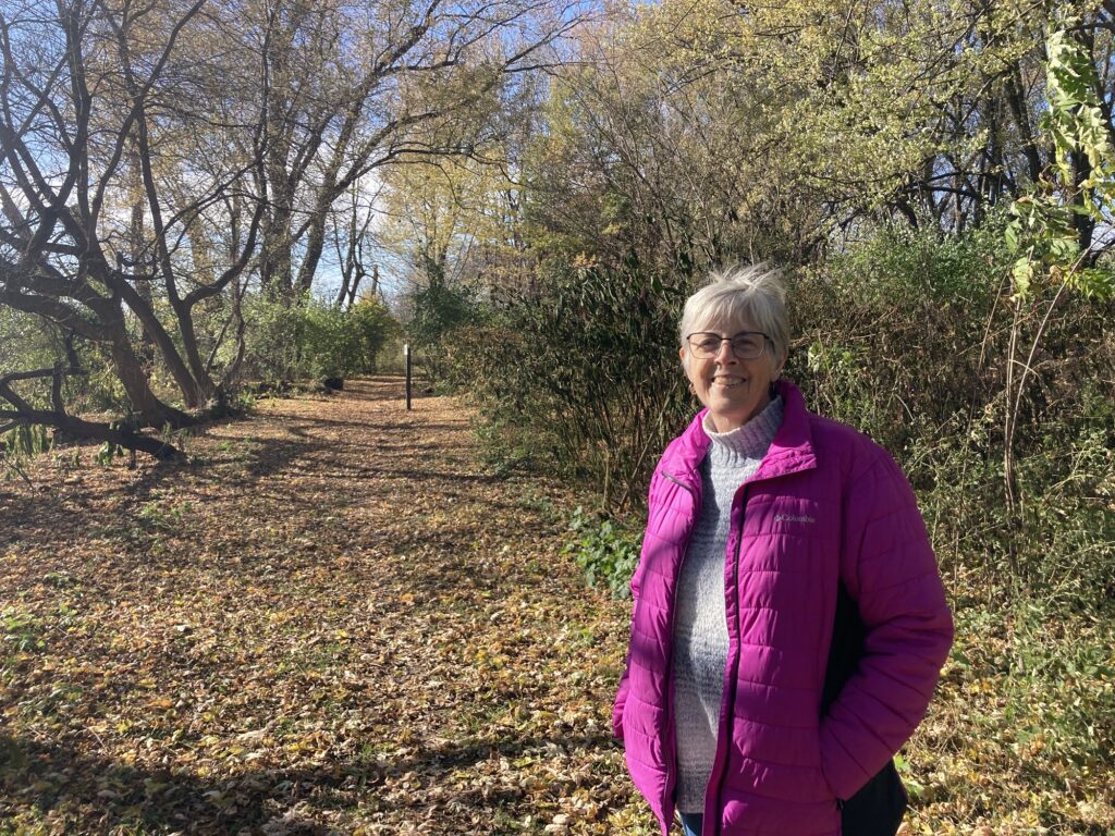 Chris Thomas walks a trail in a Madison, Wisconsin park. She’s thinking about having her memorial bench put in this area. (Photo by Alexandra Salmon)