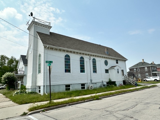The White Shul building, the former home to Adas Israel, is located on the corner of Carl Avenue and North 13th Street in Sheboygan, Wisconsin. The window was originally on the side of the building and could be seen from the street. It was replaced with a new window after former congregant David Shoenkin offered the building’s residents a new window in place of the stained glass one. (Courtesy of Phyllis Holman Weisbard)