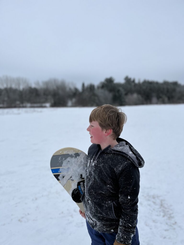 Beau Quinn looks out on the hill with his snowboard in Stockton Park, Wisconsin. (Photo by Jill Sisson Quinn)