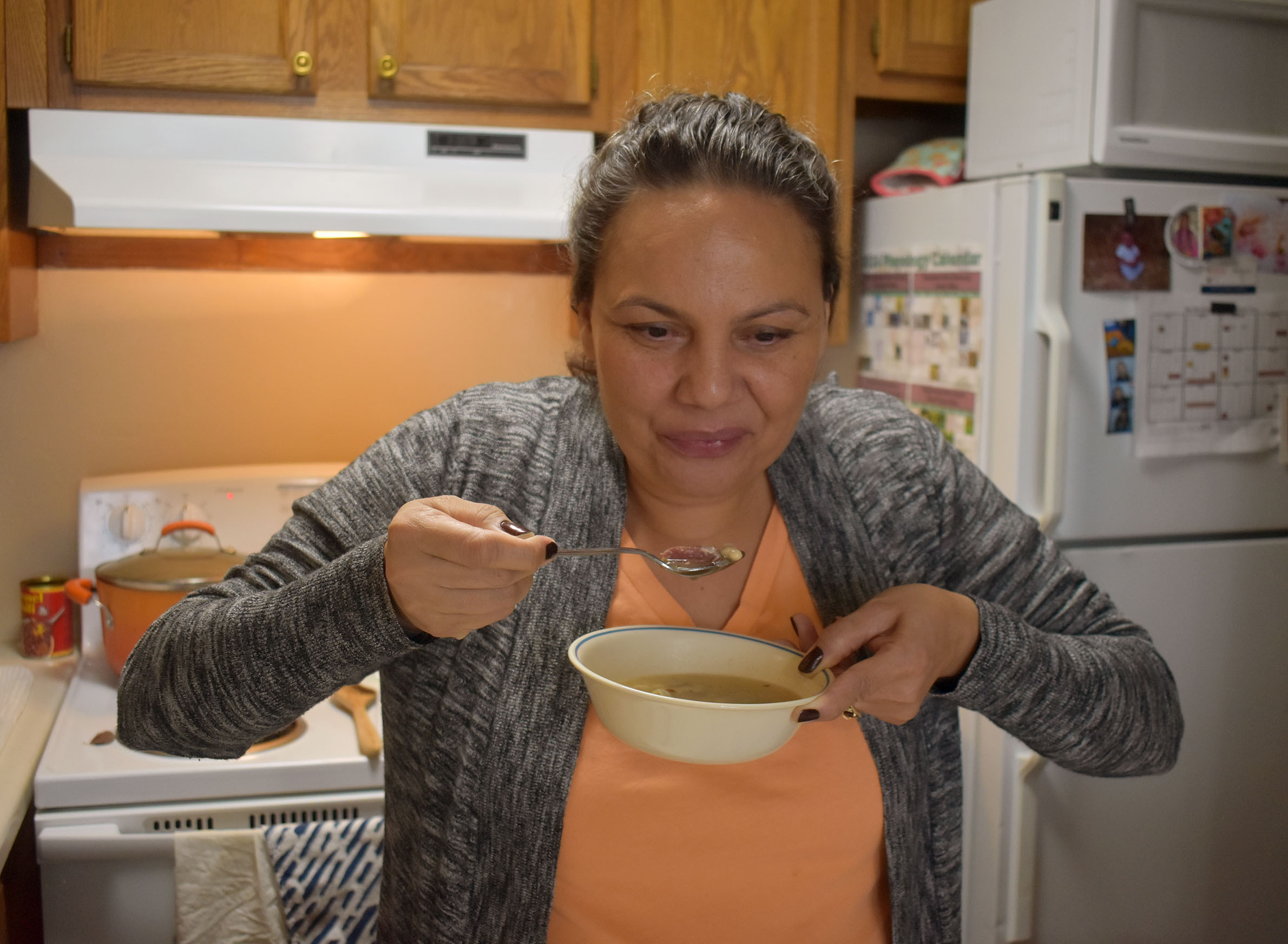Sarah Gordon Altiman eats a spoonful of Potawatomi-corn style soup that she prepared on Dec. 21, 2023. (Danielle Kaeding/WPR)