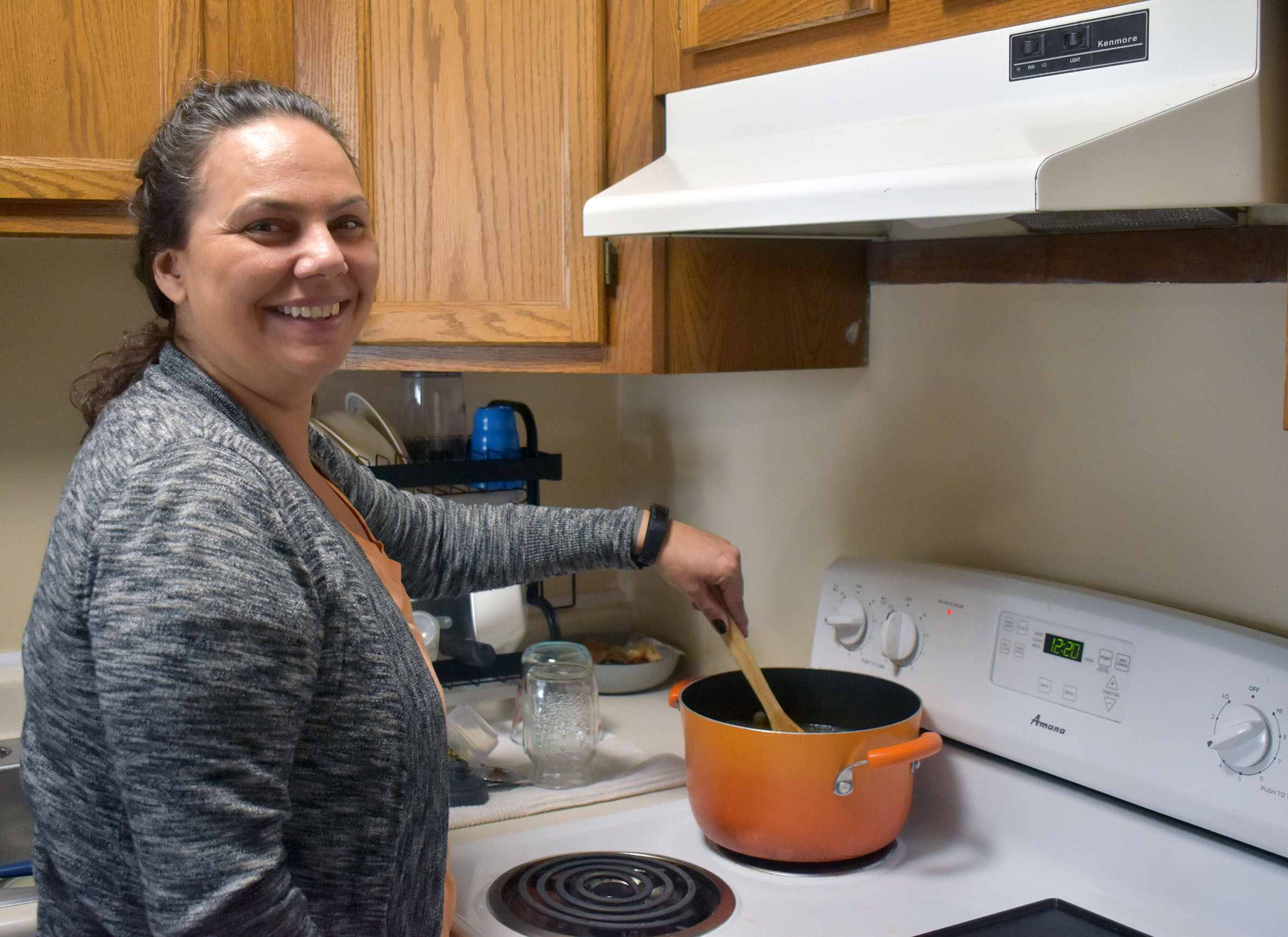 Sarah Gordon Altiman stirs a pot full of broth, pork neck bones, navy beans, onions and white dent corn as she makes Potawatomi-style corn soup on Dec. 21, 2023. (Danielle Kaeding/WPR)