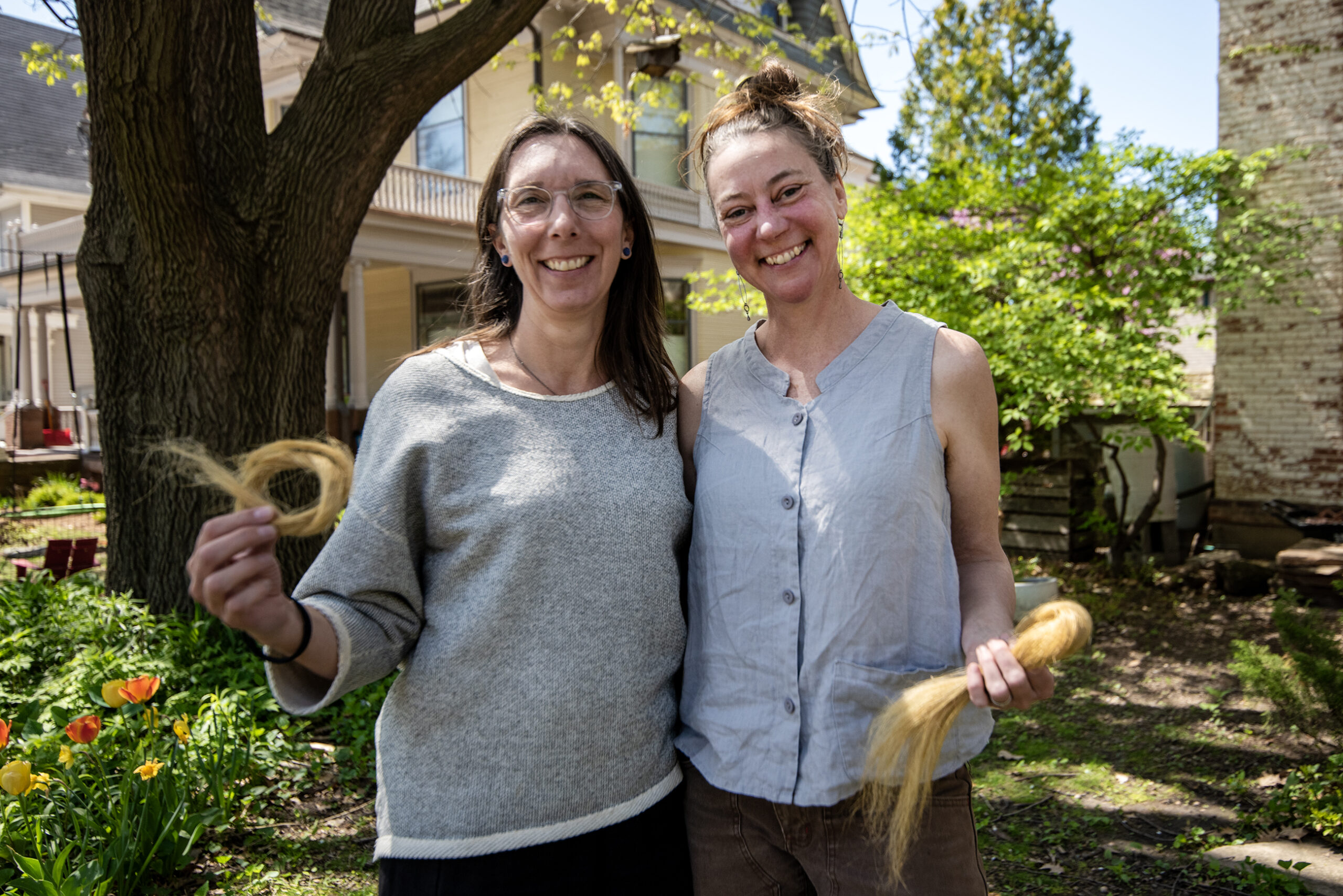 Jessica Becker, left, and Leslie Schroeder, right, hold flax Thursday, May 8, 2025, in Madison, Wis. The duo are curating and producing the Field to Frock events. <i>Angela Major/WPR</i>